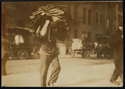 Man carrying bundle of garments. Bleecker Street, N.Y. Location: New…, New York (State), 1912