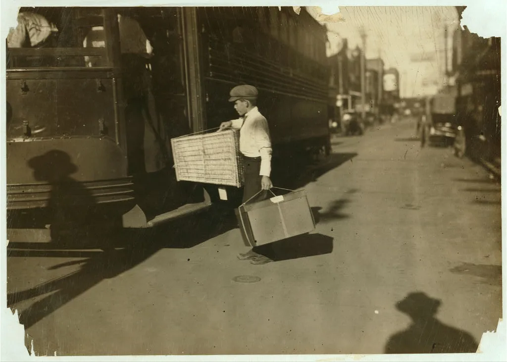 Young delivery boy with heavy bundles.  Location: Mobile, Alabama, 1914